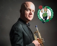 photo of bald man in a suit holding a trumpet